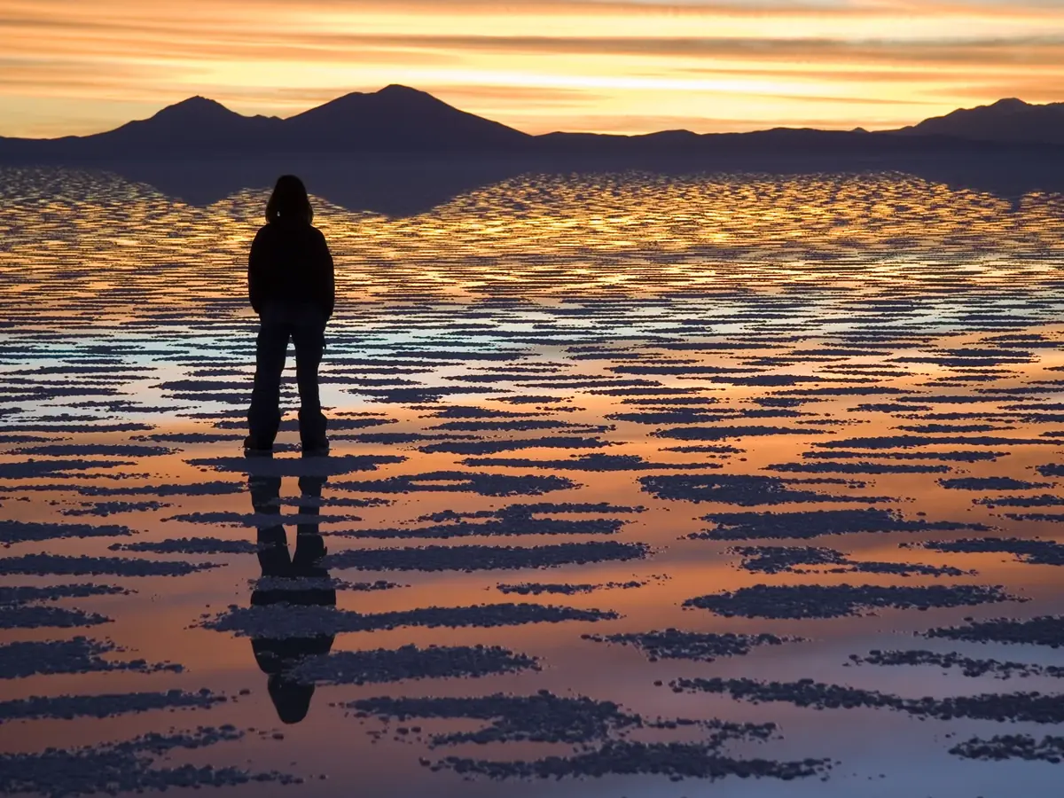 Viajero mirando el atardecer sobre el Salar de Uyuni